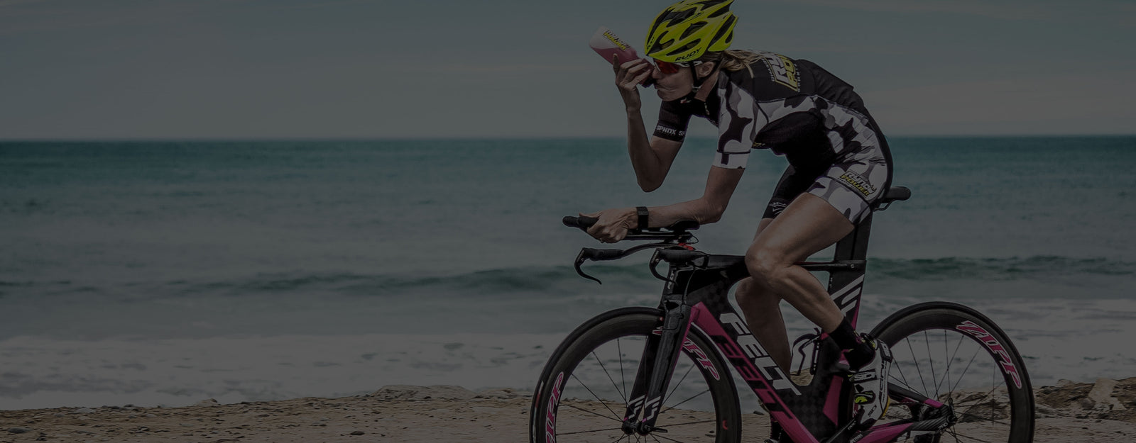 TRIATHLETE RIDING NEXT TO BEACH