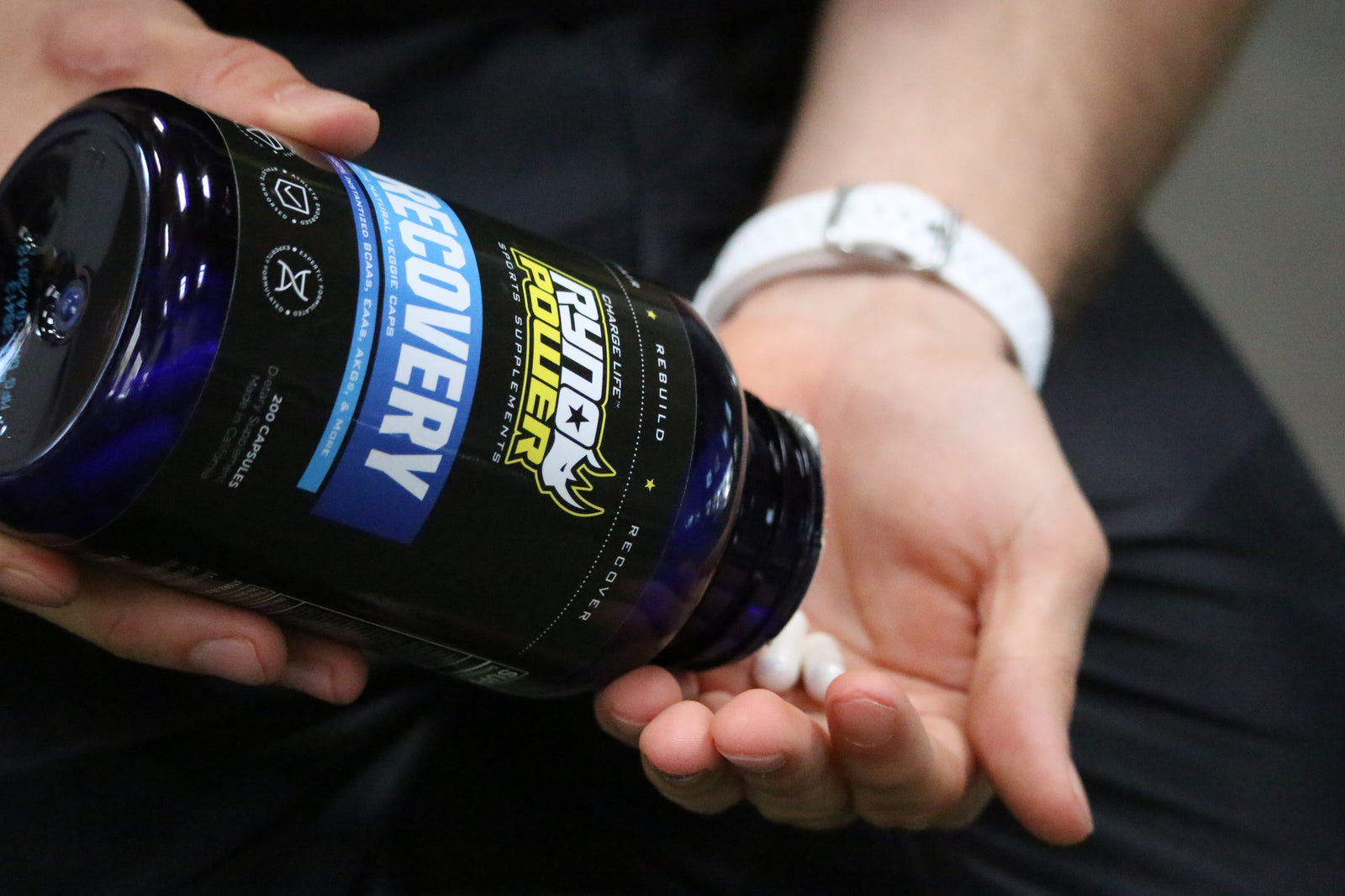 hand pouring bottle of Recovery