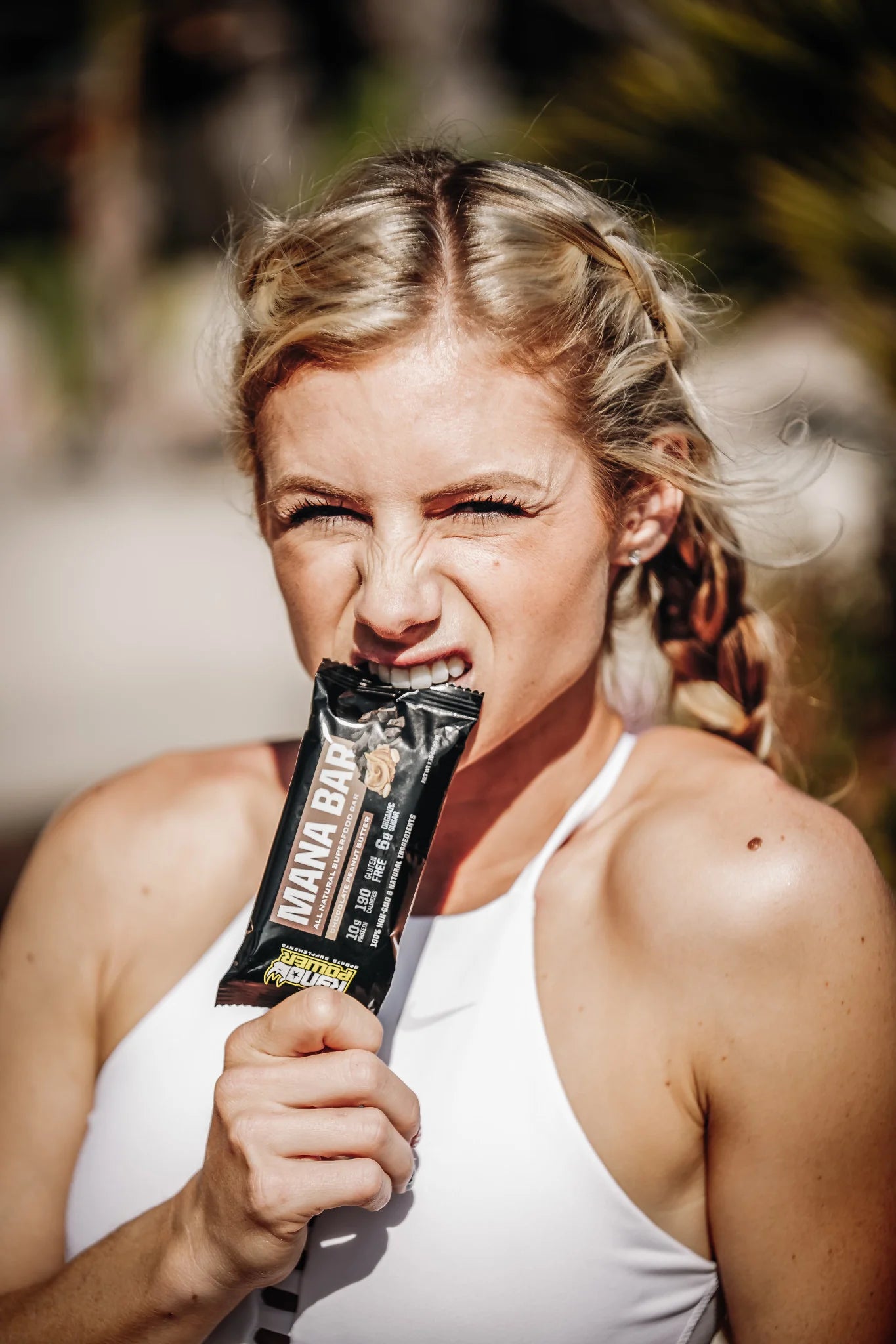 person holding a mana bar in her teeth and hand